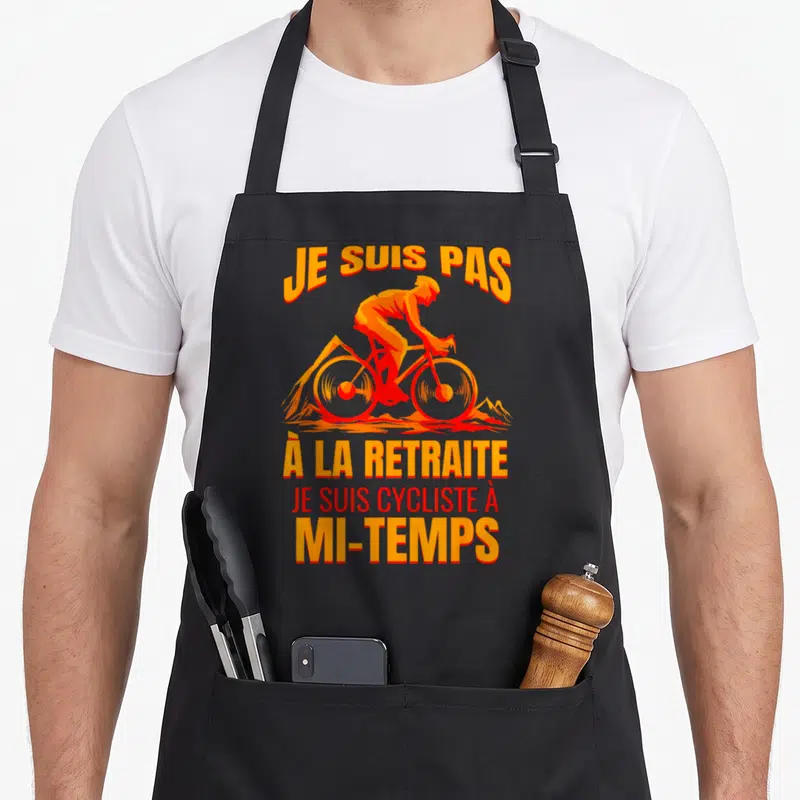 Tablier de cuisine noir avec illustration cycliste orange et texte humoristique sur la retraite.