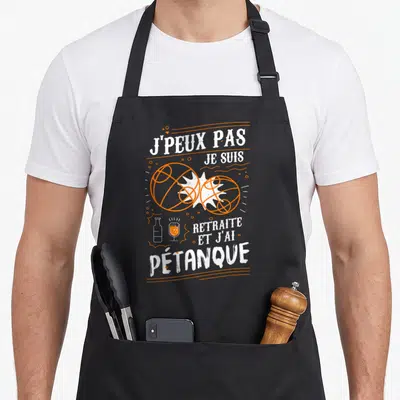 Tablier de cuisine noir avec inscription blanche J'peux pas je suis retraité et j'ai pétanque et illustration orange de boules de pétanque.