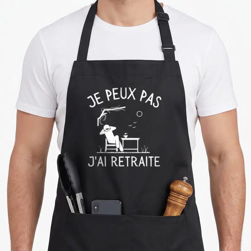 Tablier de cuisine noir avec une silhouette relaxant et le texte Je peux pas j'ai retraite imprimé en blanc.