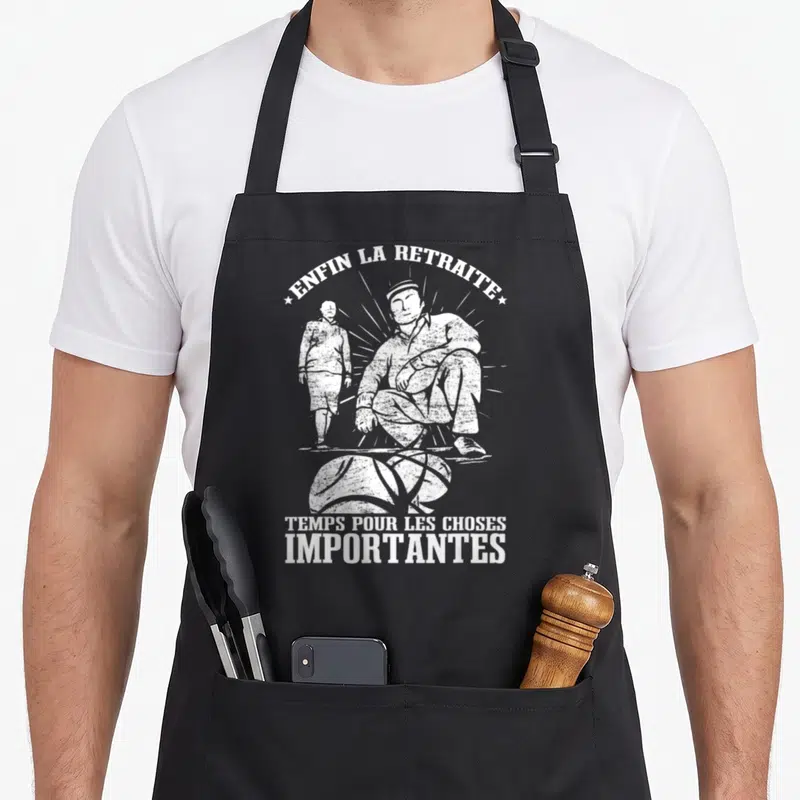 Tablier de cuisine noir avec illustration blanche d'un homme jouant à la boule lyonnaise et texte humoristique.