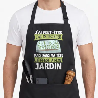 Tablier de cuisine noir avec illustration de serre et texte J'ai peut-être l'air de t'écouter mais dans ma tête je pense à mon jardin.