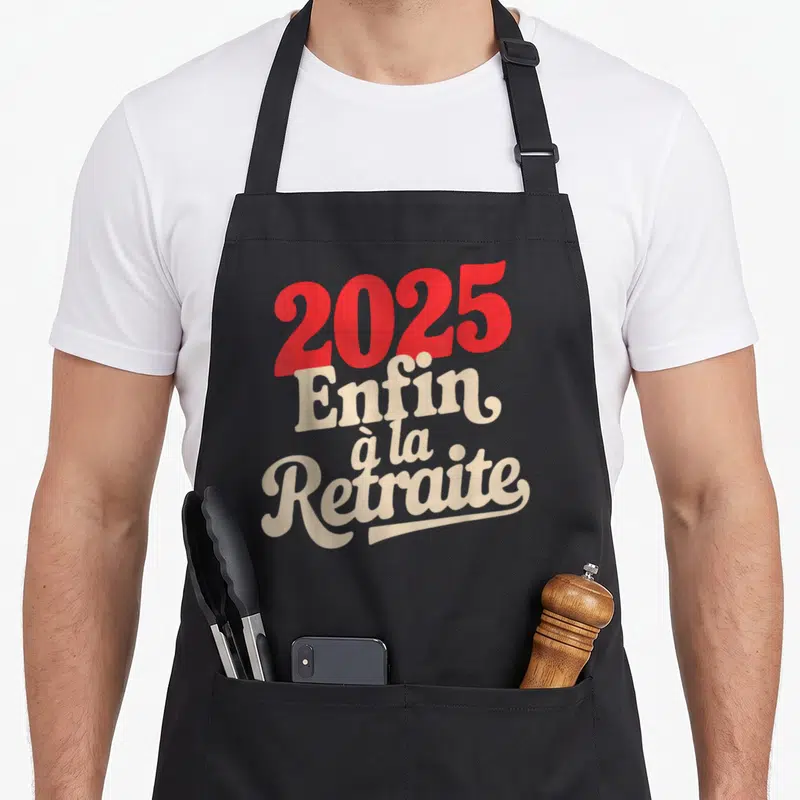 Tablier de cuisine noir avec l'inscription 2025 Enfin à la Retraite en lettres rouges et crème.