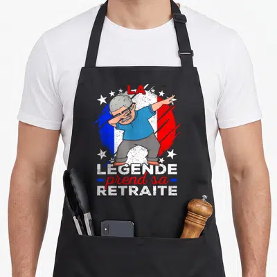 Tablier de cuisine noir avec illustration d'un homme grisant en pose dab sur fond tricolore et texte La Légende prend sa retraite.