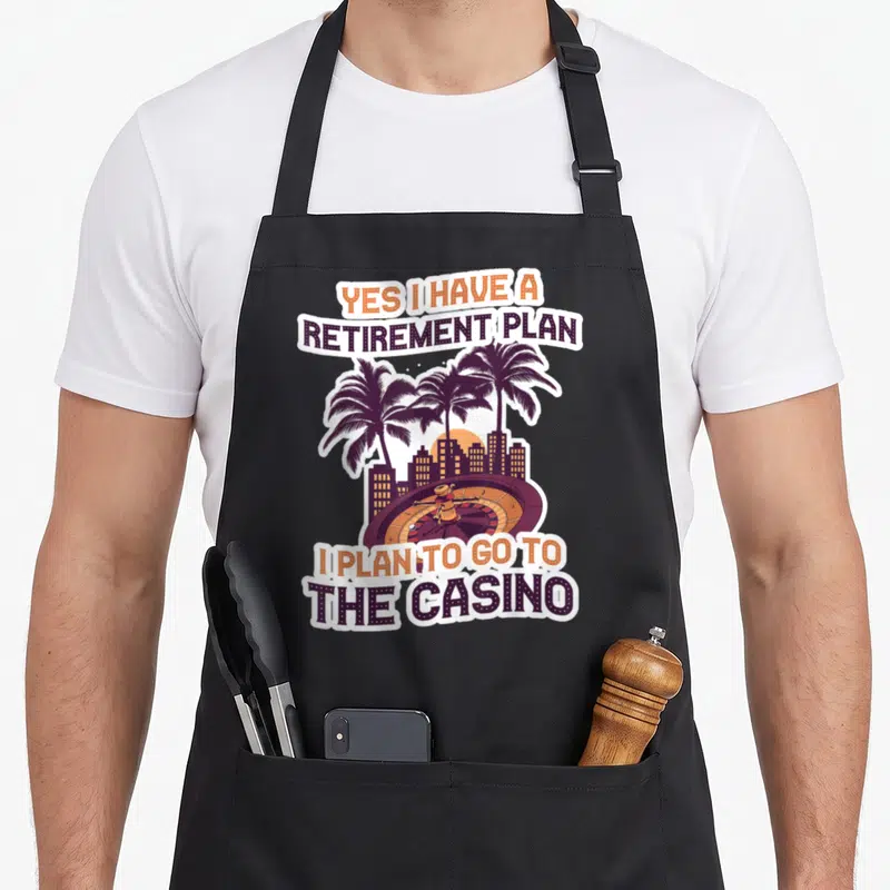 Tablier de cuisine noir avec inscription Yes I have a retirement plan et illustration de roulette sous des palmiers au coucher du soleil.