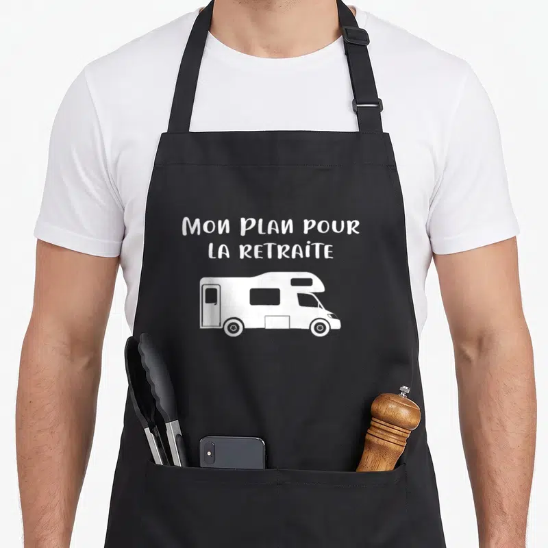 Tablier de cuisine noir avec illustration camping car et texte Mon plan pour la retraite en blanc.