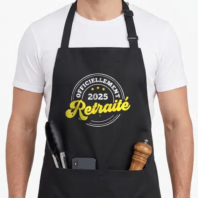 Tablier de cuisine noir avec linscription « Officiellement Retraité 2025 » en blanc et jaune au centre.