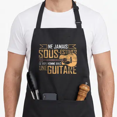 Tablier de cuisine noir avec illustration vintage d'une guitare acoustique orange et texte blanc.