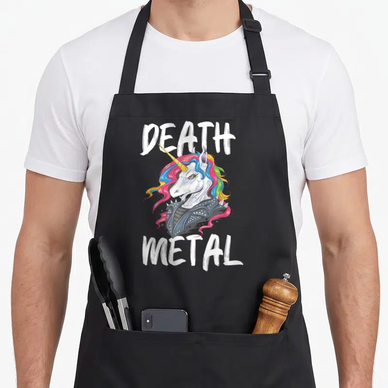 Tablier de cuisine noir avec une licorne Death Metal aux cheveux multicolores et une veste en cuir cloutée.