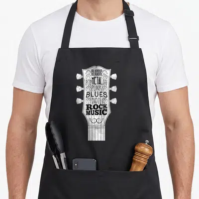 Tablier de cuisine noir avec illustration blanche en forme de tête de guitare contenant des noms de genres musicaux.
