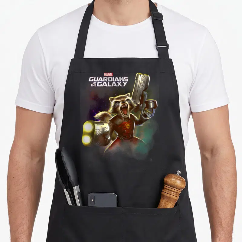 Tablier de cuisine noir avec illustration colorée de Rocket Raccoon tenant des fusils spatiaux sous le logo Marvel.