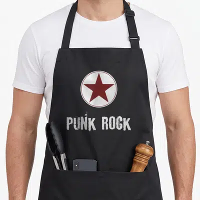 Tablier de cuisine noir avec une étoile rouge cerclée de blanc et l'inscription PUNK ROCK en typographie dégradée.