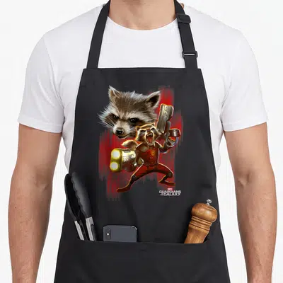 Tablier de cuisine noir avec une illustration colorée de Rocket Raccoon brandissant des armes sur fond rouge vif.