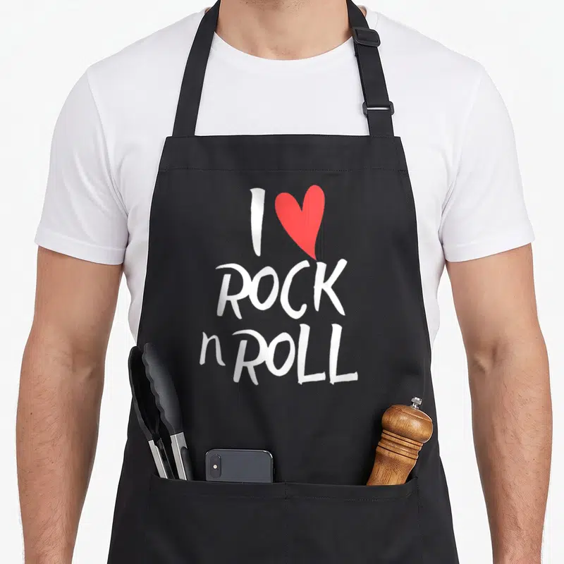 Tablier de cuisine noir avec l'inscription blanche I Love Rock n Roll et un cœur rouge au centre du motif imprimé.
