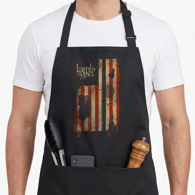 Tablier de cuisine noir avec drapeau américain déstructuré, étoiles rouges et texte Lamb of God Pure American Metal imprimé en vert beige.