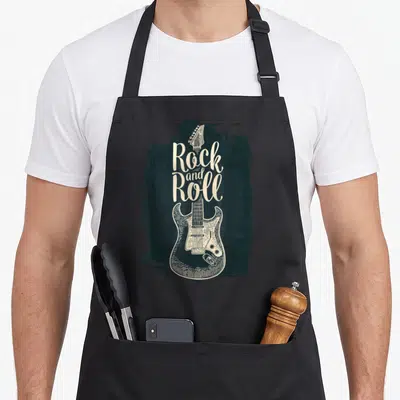 Tablier de cuisine noir avec illustration vintage d'une guitare électrique et le texte Rock and Roll en lettres blanches stylisées.