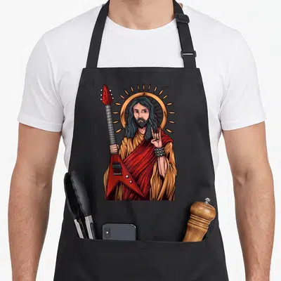 Tablier de cuisine noir avec une illustration de Jésus tenant une guitare rouge en forme de V et levant la main en signe de metal.