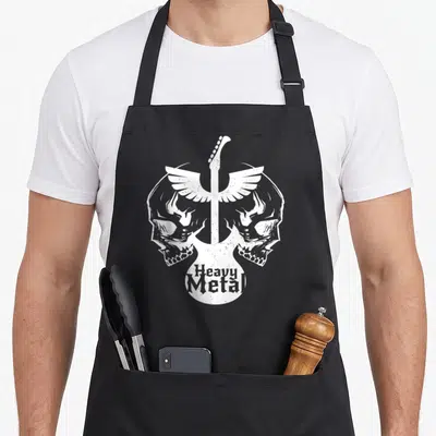 Tablier de cuisine noir avec deux skulls ailés et une guitare blanche portant l'inscription Heavy Metal