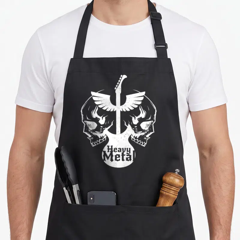 Tablier de cuisine noir avec deux skulls ailés et une guitare blanche portant l'inscription Heavy Metal