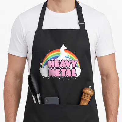 Tablier de cuisine noir avec une licorne blanche, un arc-en-ciel et l'inscription Heavy Metal en rose.