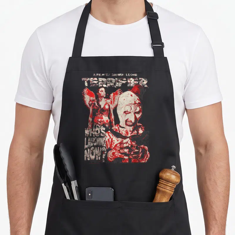Tablier de cuisine noir avec illustration rouge et blanche d'un clown terrifiant et du texte Who's Laughing Now.