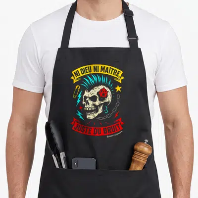 Tablier de cuisine noir avec un crâne punk à la mohawk turquoise et aux slogans Ni Dieu Ni Maître et Juste du Bruit.