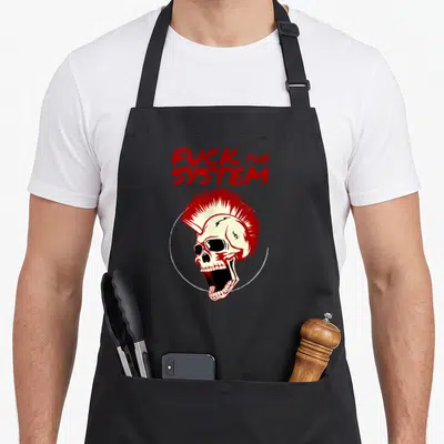 Tablier de cuisine noir avec un crâne à chignon punk rouge et l'inscription Fuck the System en lettres stylisées.