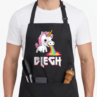 Tablier de cuisine noir avec licorne blanche vomissant un arc-en-ciel et le mot Blegh en typographie métallique.