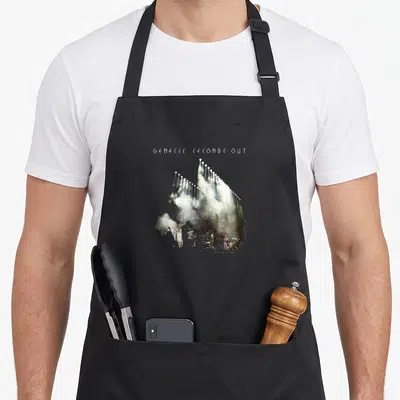 Tablier de cuisine noir avec illustration de scène de concert et texte Genesis Seconds Out en haut.