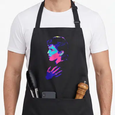 Tablier de cuisine noir avec portrait de profil rockeur aux couleurs vives et main stylisée en style pop art.