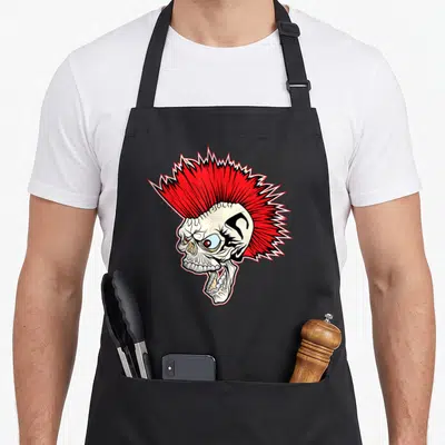 Tablier de cuisine noir avec un crâne au mohawk rouge vif et une expression punk rock agressive.