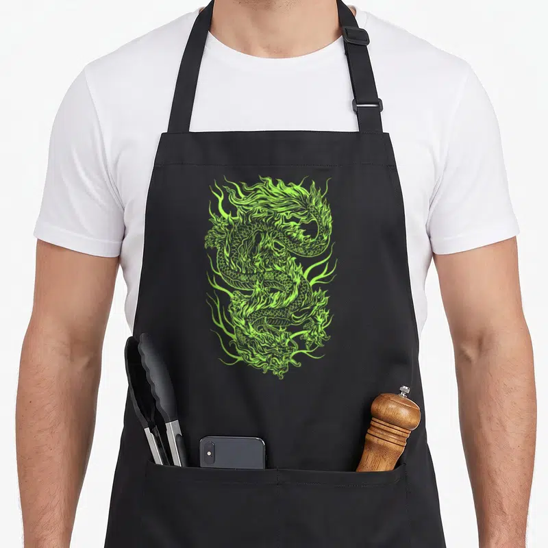 Tablier de cuisine noir avec un dragon chinois vert aux contours flammants et détaillés sur fond sombre.