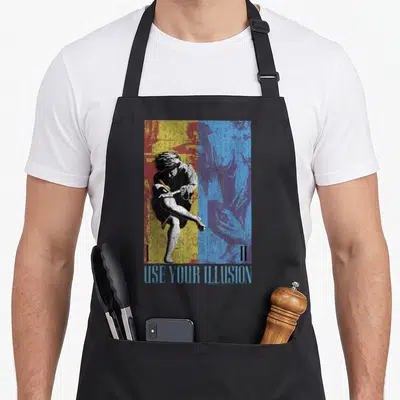 Tablier de cuisine noir avec une illustration graphique bicolore représentant un guitariste en pleine action et le texte Use Your Illusion.