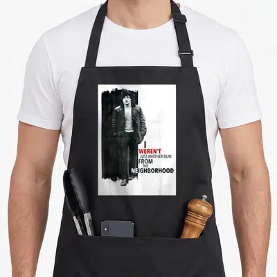 Tablier de cuisine noir avec une illustration monochrome d'un homme et un texte humoristique en anglais.
