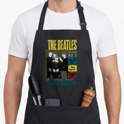 Tablier de cuisine noir avec une illustration vintage des Beatles et le texte Imperial Ballroom en bleu.