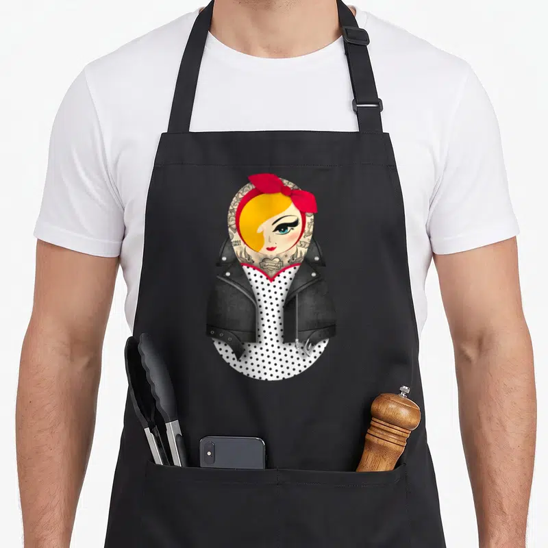 Tablier de cuisine noir avec une matriochka Jayne pin-up en robe à pois et veste en cuir noire.