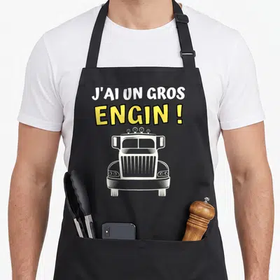 Tablier de cuisine noir avec illustration de face de camion et texte J'ai un gros engin en jaune et blanc.