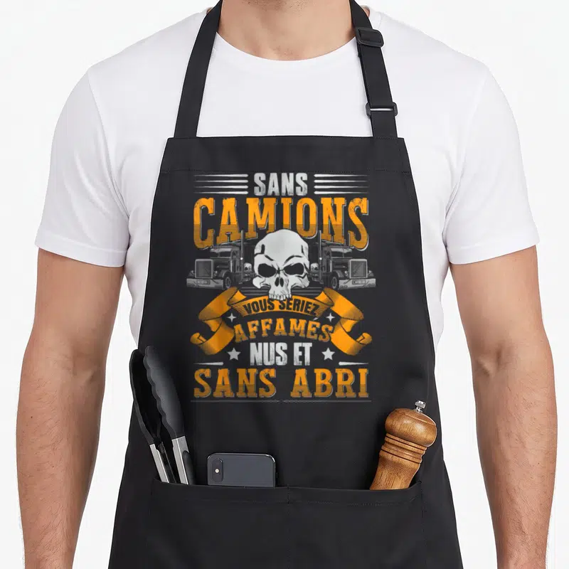 Tablier de cuisine noir avec illustration de crâne, camions et texte humoristique sur le transport routier en typographie orange et blanche.