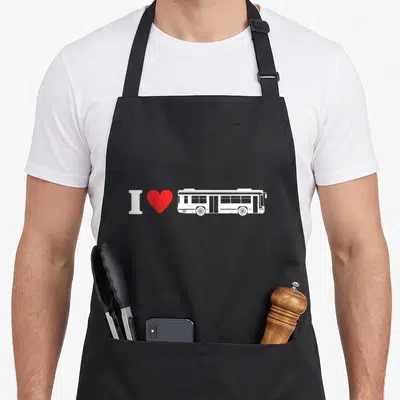 Tablier de cuisine noir avec un autobus blanc, un cœur rouge et le texte I Love Bus Driving imprimé au centre.