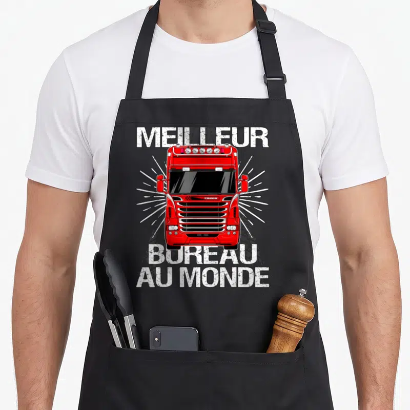 Tablier de cuisine noir avec illustration frontale d'un camion rouge et texte Meilleur bureau au monde en blanc.