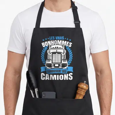 Tablier de cuisine noir avec illustration frontale d'un poids lourd blanc encadré par une couronne de laurier bleue et du texte en blanc et bleu.