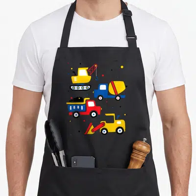 Tablier de cuisine noir avec pelleteuse, camion benne, grue et bétonnière colorés sur fond uni.