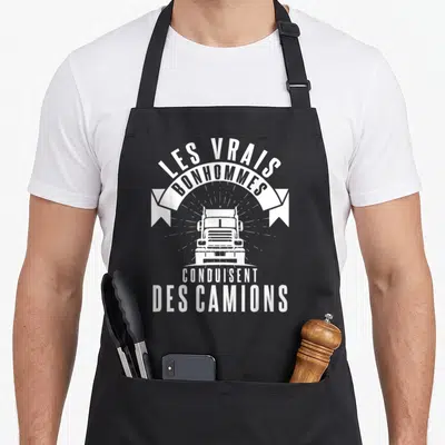 Tablier de cuisine noir avec inscription Les vrais bonhommes conduisent des camions et illustration de truck blanc face avant.