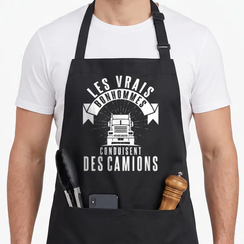 Tablier de cuisine noir avec inscription Les vrais bonhommes conduisent des camions et illustration de truck blanc face avant.