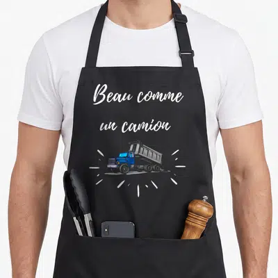 Tablier de cuisine noir avec illustration d'un camion bleu et texte Beau comme un camion en lettres blanches.