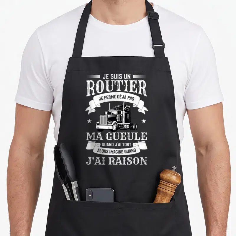 Tablier de cuisine noir avec illustration de semi-remorque et texte blanc humoristique sur fond uni.