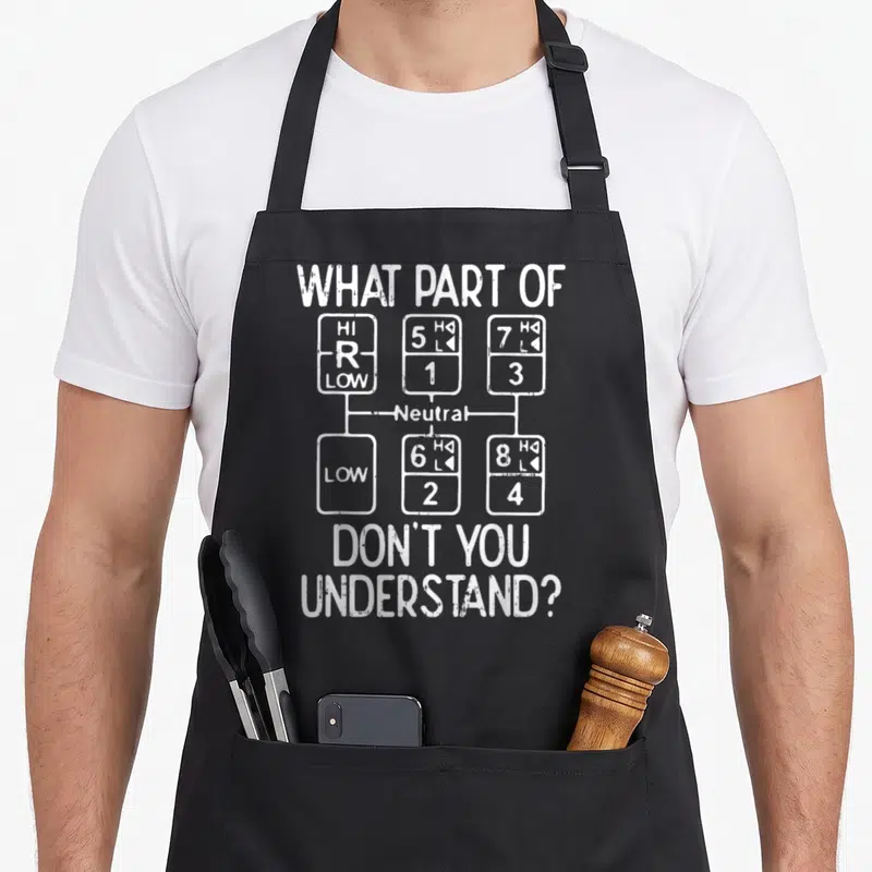 Tablier de cuisine noir avec schéma blanc de boîte de vitesses routière et texte humoristique en anglais.