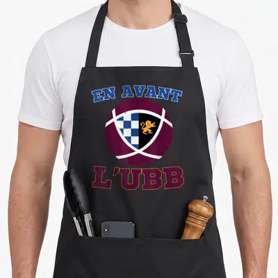 Tablier de cuisine noir avec ballon de rugby violet, blason à damier bleu et lion doré, et texte En Avant l'UBB