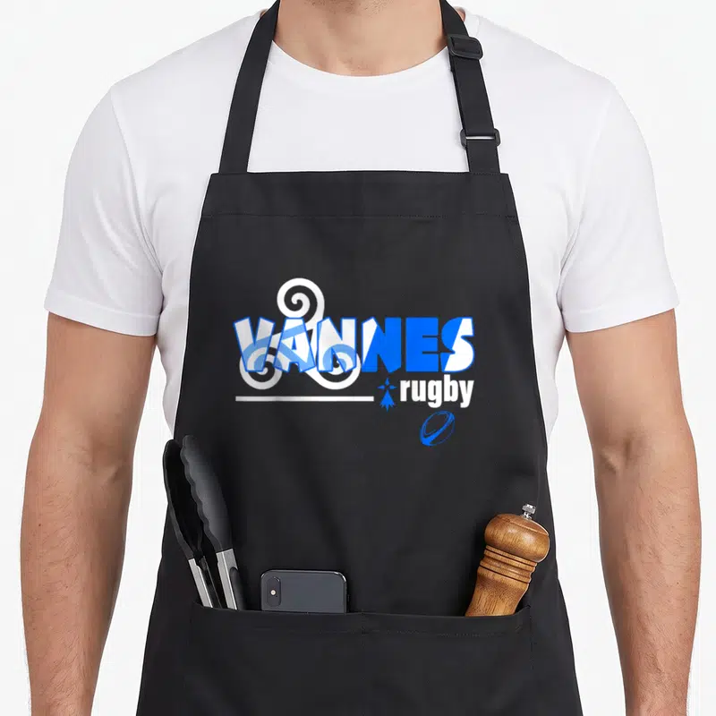 Tablier de cuisine noir avec inscription Vannes Rugby en bleu et blanc orné d'un motif décoratif et d'un ballon stylisé.