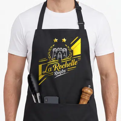 Tablier de cuisine noir avec le logo La Rochelle Rugby, deux étoiles dorées et une tour blanche encadrée de couronnes de laurel.
