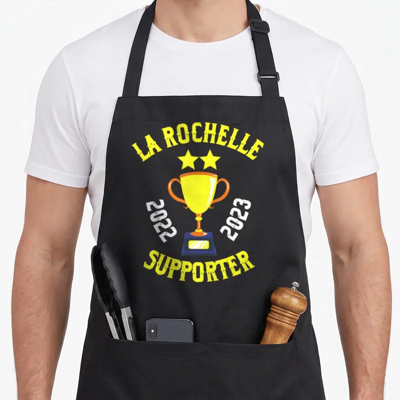 Tablier de cuisine noir avec un trophée jaune, deux étoiles et le texte La Rochelle Supporter 2022 2023.